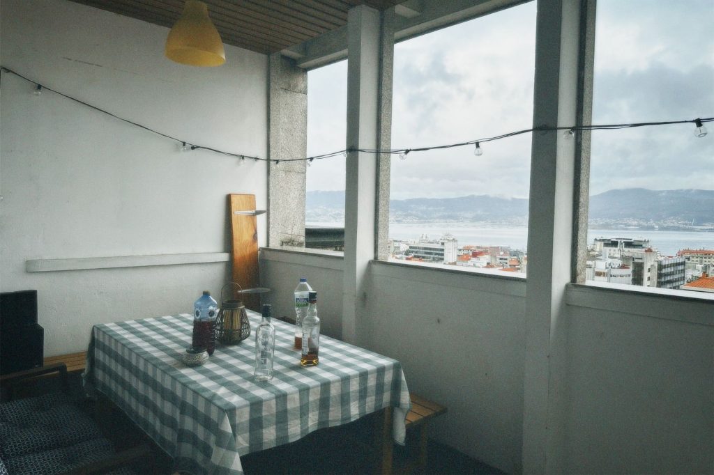 Cozy rooftop terrace with city view and checkered tablecloth dining setup.