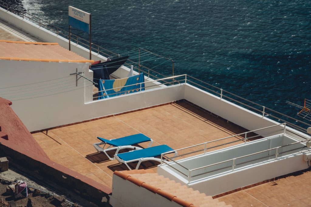 Sunny rooftop terrace with loungers overlooking the ocean in Alojera, La Gomera.